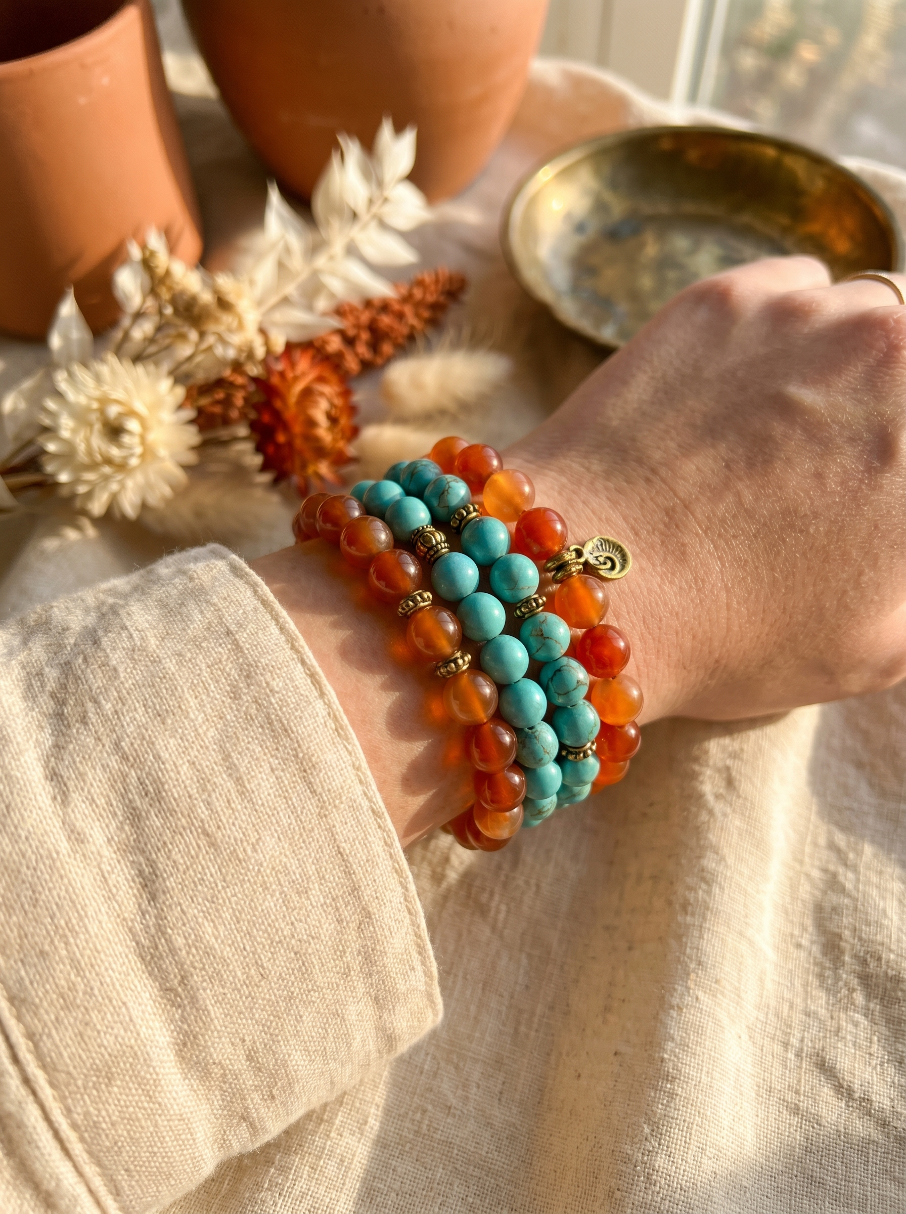 Stacked carnelian and turquoise gemstone bracelets on wrist